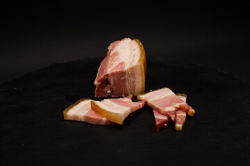 A detailed shot of bacon on a black background - Powered by Adobe
