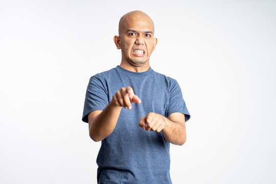 angry asian bald man pointing ahead while standing on isolated background
