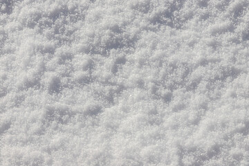 Obraz premium Beautiful winter background with snowy ground. Natural snow texture. Wind sculpted patterns on snow surface