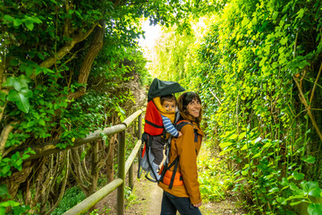 A mother with her son on a path at Barro beach on the Borizu peninsula in the town of Llanes. Asturias. Spain