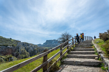 Fototapeta na wymiar Three generations on the stairs of the path towards the lakes of Covadonga. Asturias. Spain