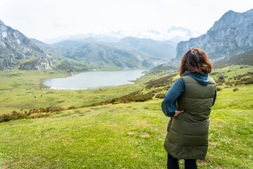 Naklejka na ściany i meble A young tourist enjoying the views at the Entrelagos viewpoint of Lake Ercina in the Lakes of Covadonga. Asturias. Spain