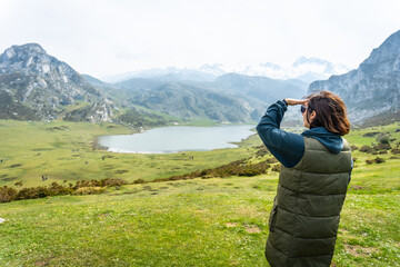 Naklejka premium A young tourist enjoying the views at the Entrelagos viewpoint of Lake Ercina in the Lakes of Covadonga. Asturias. Spain