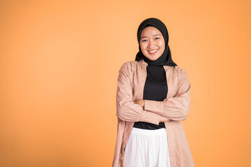 young asian muslim woman stand with crossed hands on isolated background