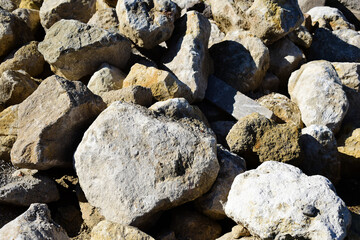 Hintergrund Steine und Felsen, grobe, große Steine im Sonnenlicht mit Schatten