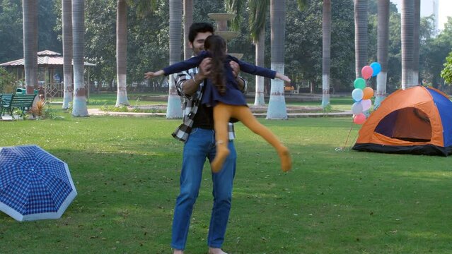An Indian father playing with her school-going daughter - childhood game  a fun activity. A handsome guy and a little girl together in a public park - leisure time  parent-child relationship  a ple...