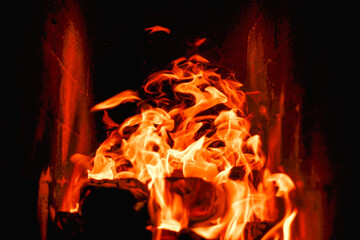 Burning firewood and coals in a stone stove. Brick oven on wood. Long tongues of flame of burning fire
