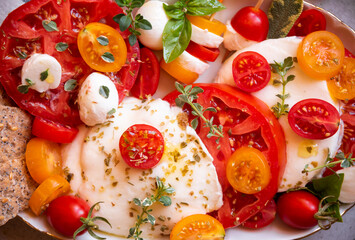 Caprese salad, tomatoes with mozzarella cheese and basil. Healthy vegetable meal