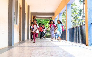 Enjoying group of kids running at school corridor for going to classroom - concept of education, reopen school, active childhood and learning.