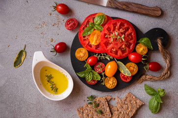 Various tomatoes served with basil. Healthy vegetable meal