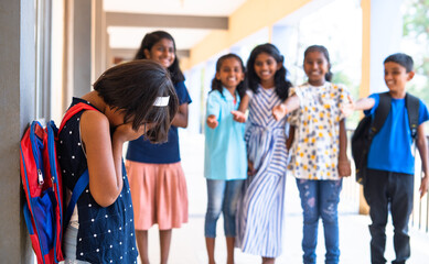Girl kid being bullied by group of children at school corridor - concept of rejection, innocent and...