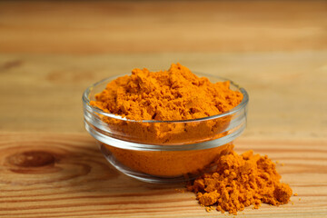 Aromatic saffron powder in bowl on wooden table