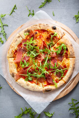 Top view sliced ​​pizza with meat jamon and arugula