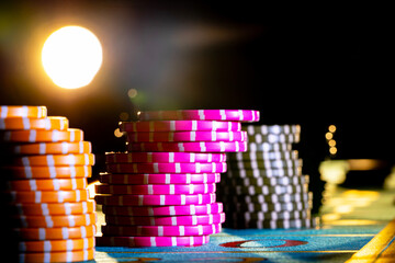 Set of colored chips for gambling in casino on a black background. Yellow and pink gaming chips on...
