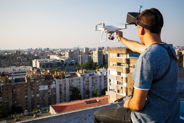 Man operating a drone with remote control on rooftop