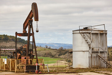 Fototapeta na wymiar Rusty oil pumping machine. Pump jack. Petroleum extraction