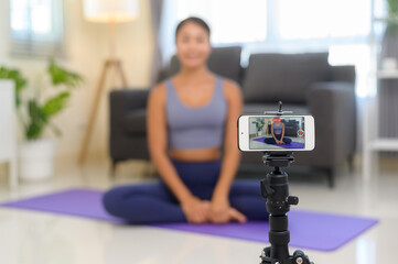 Fototapeta na wymiar Professional yoga coach teaching online training class to students during live streaming on social media, healthcare concept