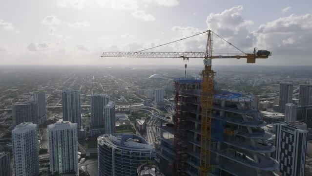 alt flying counter clockwise around construction crane atop skyscraper in Miami