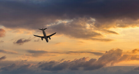 Fototapeta na wymiar Aircraft flyingon a sunset background