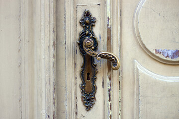 Old door handle. Wooden entrance door with antique door handles. Selective focus