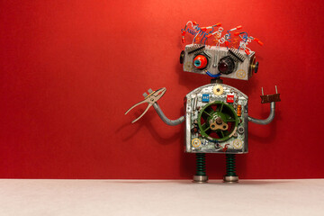 Steampunk toy robot with red pliers. Robotics character mechanic handyman on red background copy...