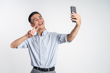 happy asian man taking selfie with phone camera on isolated background