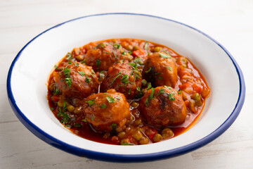 Veal meatballs in sauce with peas and tomato. Traditional Basque country tapas in the north of Spain.