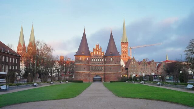 Zeitraffer vor dem Holstentor (Holstein-Tor) in L&uuml;beck / L&uuml;becker Stadttor mit L&uuml;becker Skyline