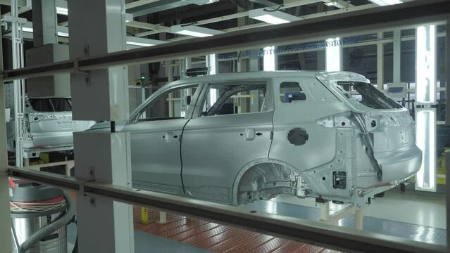 The car frame moves along the conveyor belt.