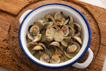 Cockles cooked in green sauce. Traditional Basque country recipe. Spanish cover.