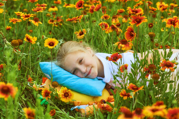 Happy little girl lying on the grass