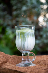 Homemade Iced Green matcha tea mixed with ice cube and almond milk. 