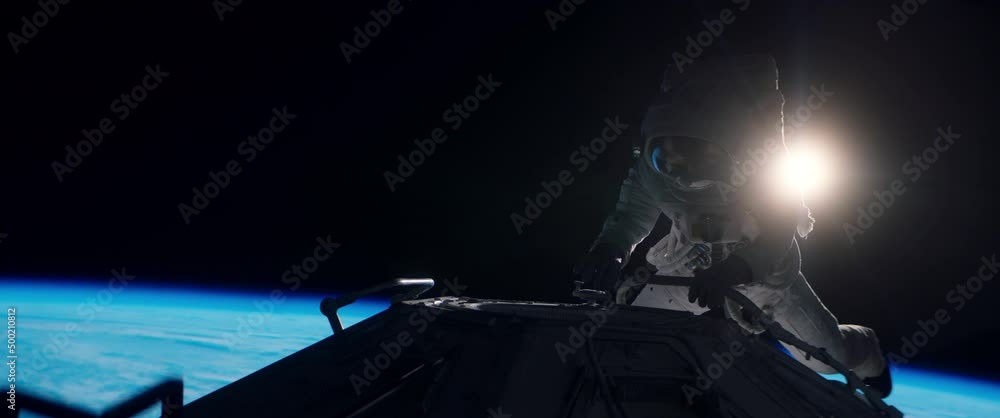 Wall mural portrait of female astronaut performing spacewalk, working on a outer part of a space craft. space e