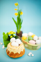 Easter background with colored eggs, easter cake, spring flowers on a blue background. Happy Easter. 