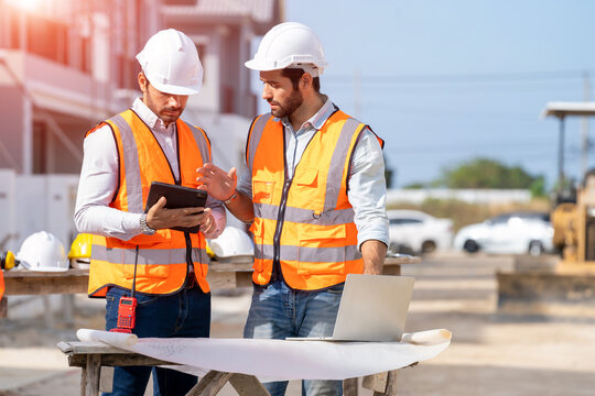 Engineer and architect discussing building plan at construction site,Group of builders having conversation about building plan,business,building,industry,people concept.