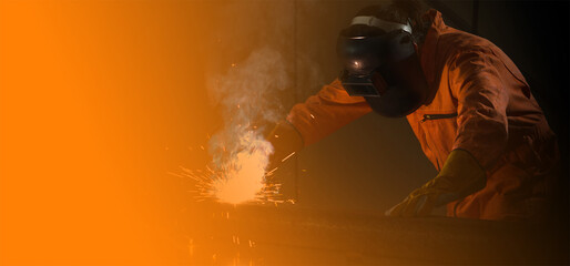 Metal industry worker are welding steel sheet for real estate projects received. Sparkler on black...