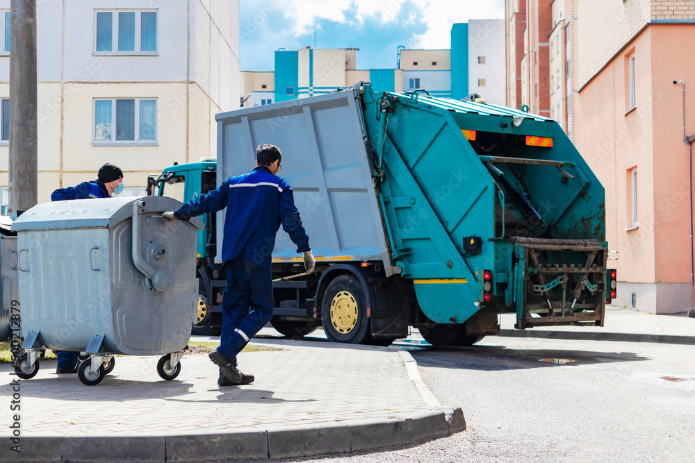 Poster an automobile garbage truck collects garbage in residential areas of a modern city. close-up of a ca