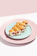Alternative maki roll with chicken on coloured background. Sushi roll with chicken, cheese and tomato inside, bread crumbs outside. Maki sushi in minimal style. Japanese menu concept.