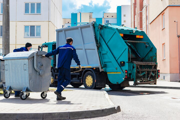 An automobile garbage truck collects garbage in residential areas of a modern city. Close-up of a...