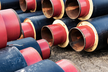 Insulated pipe. Large metal pipes with a plastic sheath at a construction site. Modern pipeline for supplying hot water and heating to a residential area.