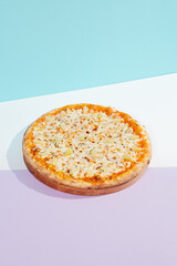 Italian pizza with chicken and pineapple on coloured background. Hawaiian pizza with chicken in minimal style on purple and blue colours. American pizza delivery concept with color backdrop