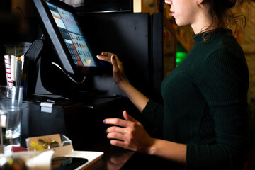 Fototapeta na wymiar Waitress charging a table on an electronic screen in a night club bar