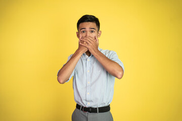 portrait of a man with hands covering mouth standing with isolated background