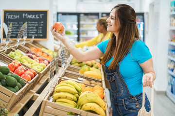 Female customer buying organic food fruits inside eco fresh market - Focus on woman face