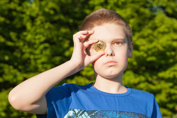 The boy's fingers supporting bitcoin near the eye