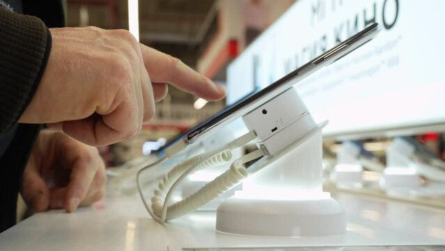 Customer choosing smartphone in mobile phone shop. Smartphones is sold at mobile phones store.