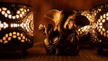 Golden ganesha figure with warm candle light. Meditation and worship concept