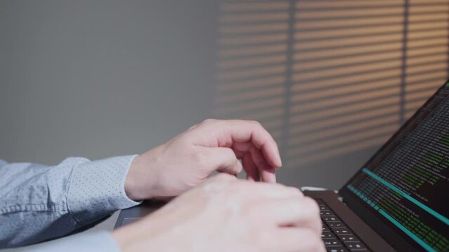Back end developer working in computer in IT office, sitting at desk writing codes. Programmer typing data code, working on project in software development company. Terminal with coding language. 