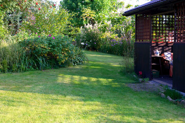 Summer house in the beautiful backyard green garden landscape and fresh, green lawn background with a lot pf space.