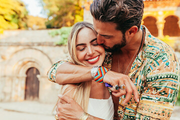 Young attractive couple hugging and kissing in front of villa castle. Man kissing his girlfriend on the cheek during summer holiday vacations. Copy space.